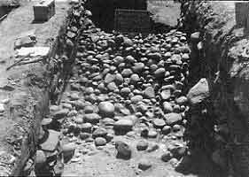 Figure 8.23 View west of wall (Strata V). The first layer of revestimento (glacis) cobbles were removed from Strata III. Fort Guijarros Museum Foundation Photo Collection, P:81-7272.